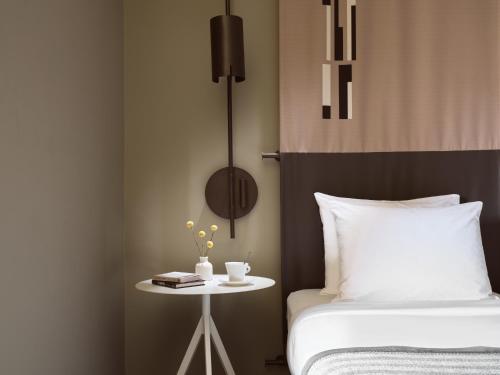a bedroom with a bed and a table with a book at City Hotel Thessaloniki in Thessaloniki