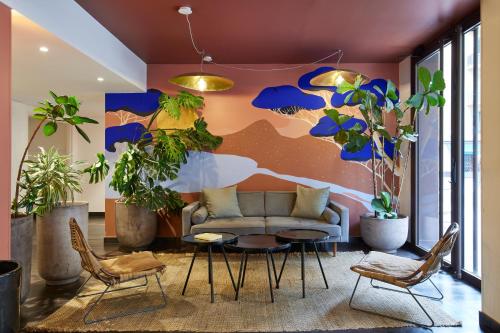 a living room with a couch and a table and chairs at Hotel du Pin Nice Port in Nice