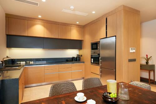 a kitchen with wooden cabinets and a wooden table at Root Redrock Yalıkavak in Yalıkavak