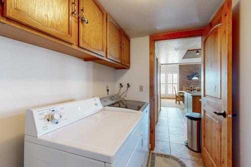 una cucina con lavastoviglie bianca e armadietti in legno di Village Round Dreams a Park City