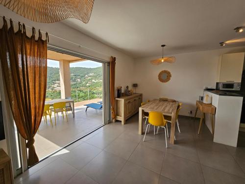 une cuisine et une salle à manger avec une table et des chaises dans l'établissement SERENA-Piscine privée- Vue Mer, à Conca