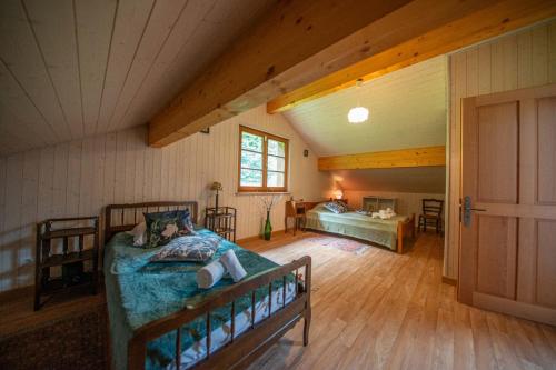Una habitación abuhardillada con una cama y un dormitorio. en La ferme aux belles sources, en Dommartin-lès-Remiremont