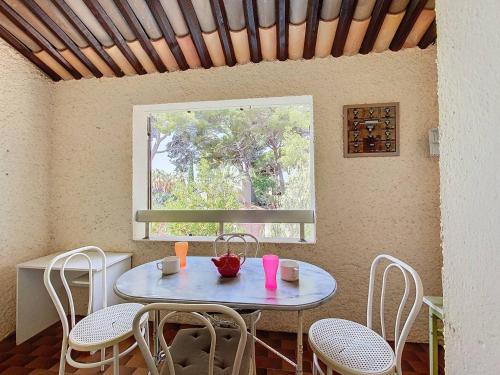 une table et des chaises dans une pièce avec une fenêtre dans l'établissement Charmant T2 avec terrasse ombragée proche plage - 4 pers, parking privé - FR-1-770-5, à Saint-Cyr-sur-Mer