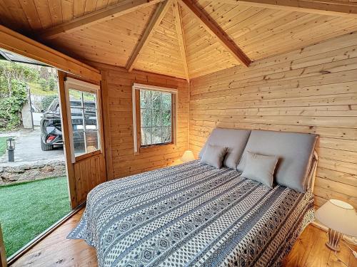 une chambre avec un lit dans une cabane en bois dans l'établissement 55m2 Charmante maison mitoyenne, jardin, parking, à Cannes