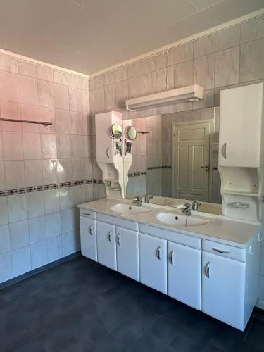 a bathroom with two sinks and a large mirror at FERRYtale, cozy, spacious house on Senja in Gryllefjord