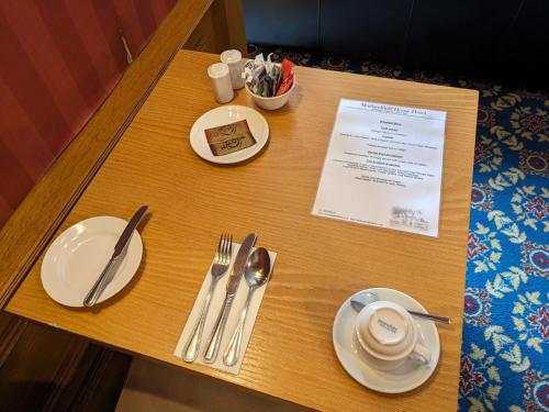 a table with white plates and utensils on it at Maitlandfield House Hotel in Haddington