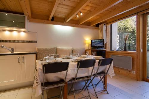 Un comedor con una mesa con copas de vino encima. en Résidence Grand Roc - Campanules 125 Happy Rentals, en Chamonix-Mont-Blanc