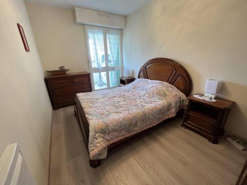une chambre avec un lit, une commode et une fenêtre dans l'établissement Appartement T2 entre plage et commerces, loggia, parking privé, proche pistes cyclables - FR-1-324A-60, à Saint-Hilaire-de-Riez