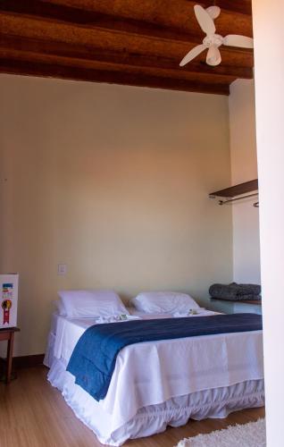 a bedroom with a bed with a ceiling fan at Toya Hotel in Ilha Comprida