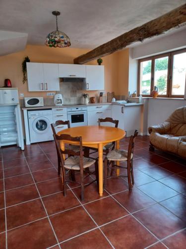 une cuisine et une salle à manger avec une table et des chaises dans l'établissement La Biste, à Mirepoix