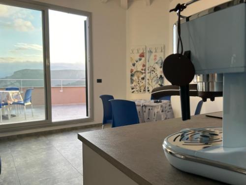 a kitchen with a stove and a view of a balcony at Eufonia del Mare in Finale Ligure