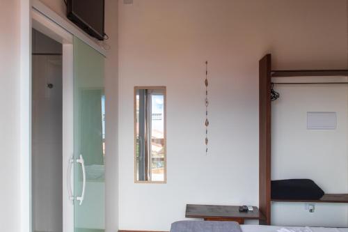 a bedroom with a glass door and a mirror at Toya Hotel in Ilha Comprida
