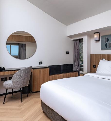 a hotel room with a bed and a mirror at Faqra Hills Hotel in Kfardebian