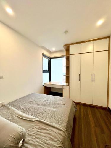 a bedroom with a bed and a desk and a window at LeeVy Hai Phong in Hai Phong
