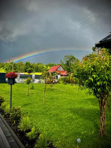 a rainbow in the sky over a green field at Domek pod Tatrami Jurgów noclegi in Jurgów
