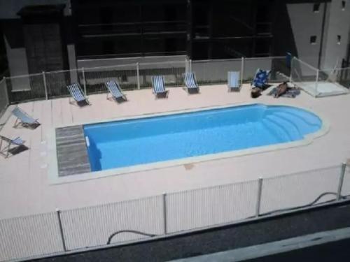 - une piscine dans un bâtiment avec des chaises dans l'établissement T2 cabine avec balcon, piscine et parking à Luz-Saint-Sauveur, proche commodités et stations de ski - FR-1-402-140, à Luz-Saint-Sauveur
