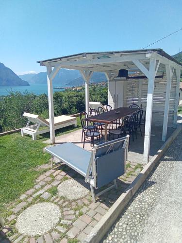 a picnic table and chairs under a pavilion at Cà Negra Ca negra suite in Costa Volpino