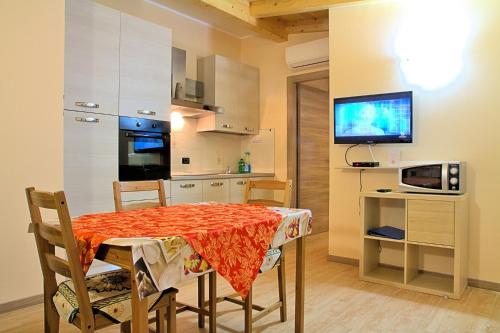 a kitchen and dining room with a table and a television at Agriturismo Il Melograno in Tessera