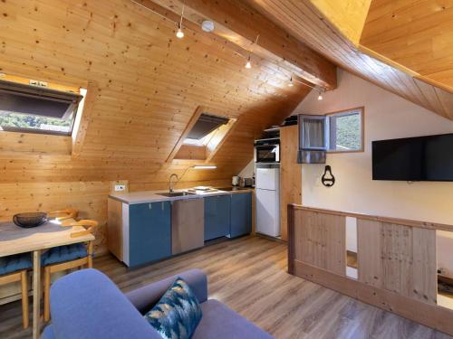 une cuisine et un salon dans une cabane en rondins dans l'établissement Charmante maison de village à Luz-Saint-Sauveur, 4 pers., proche pistes, poêle à bois, parking. - FR-1-402-141, à Luz-Saint-Sauveur