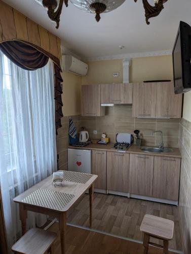 a small kitchen with a table and a sink at Едем in Skhidnitsa