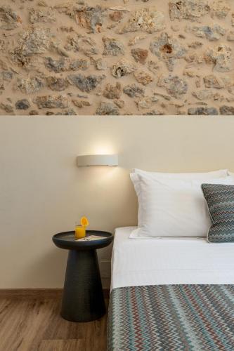 a hotel room with a bed and a table next to it at YeeOn Living-Well Boutique City Hotel Gythio in Gythio