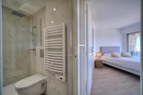 La salle de bains est pourvue d'une douche, de toilettes et d'un lit. dans l'établissement A2B232 Bel appartement vue mer et proche plage, à Cannes