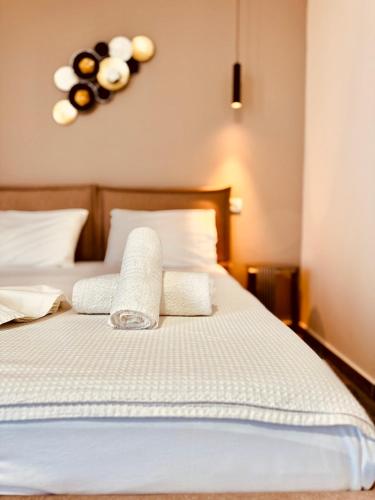 a bed with white sheets and towels on it at Villa Merkuri in Himare