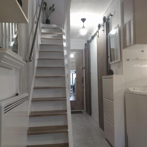 - un escalier blanc dans une chambre avec couloir dans l'établissement Appart au cœur des pins - 2 chambres - 6 personnes-clim-parking, au Cap d'Agde