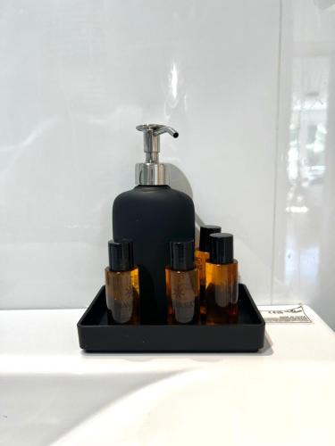 a black soap dispenser sitting on a bathroom counter at Wolu suites in Brussels