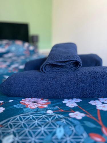 - un lit avec une couverture bleue dans l'établissement Le Blue Twin, au Havre