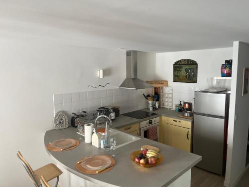 une cuisine avec un comptoir avec un bol de fruits dessus dans l'établissement Bel appartement centre ville de Foix, à Foix
