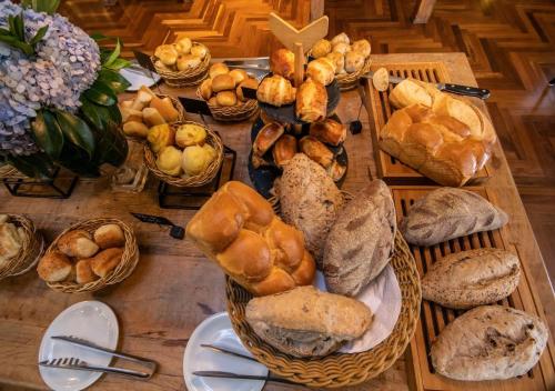 a table filled with lots of different types of bread at Hotel Vila Inglesa in Campos do Jordão