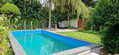 a swimming pool in a garden with a bench at Relax apartmán Pod Javorem in Kladno