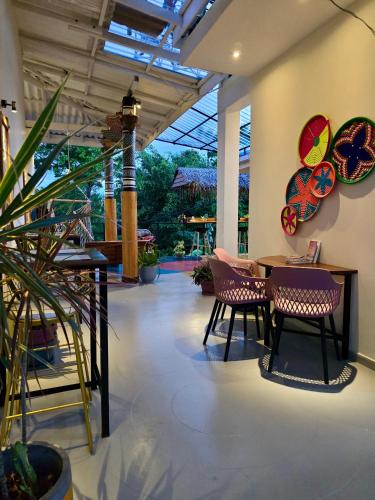 a patio with a table and chairs and a plant at Habibi Hostel & Restaurant in Unawatuna
