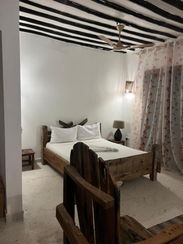 a bedroom with a bed and a ceiling fan at Malcom Ocean View Retreat in Pongwe