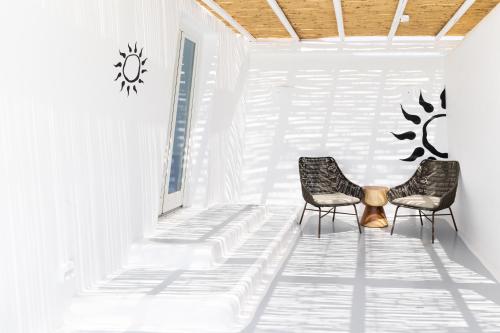two chairs and a table in a room at Frati Villas Beachfront in Perivolos