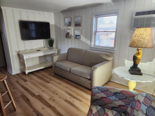 a living room with a couch and a television at Beach Bum West-O Cabins in Ocean City