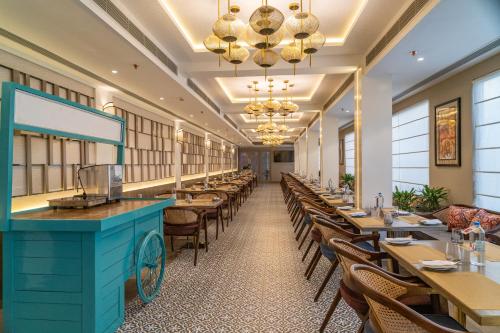 a row of tables and chairs in a restaurant at Regenta Place Amritsar by Royal Orchid Hotels Limited in Amritsar