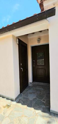 a house with a door and a stone patio at Villa Dimitra in Agios Dimitrios