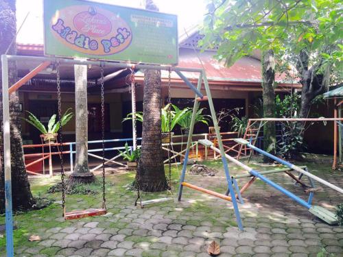 a playground in front of a building with a sign at Rufina's Leisure Center in Tagum