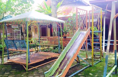 a playground with a slide and a swing set at Rufina's Leisure Center in Tagum