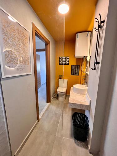 a bathroom with a toilet and a sink at BiSuite Urla in Kuscular