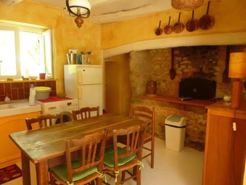 a kitchen with a wooden table and chairs and a stove at Maison charmante à Les Junies avec vue sur jardin in Les Junies
