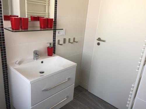un bagno con un lavandino bianco e uno specchio di Sonnige Ferienwohnung a Borkum