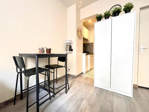 une cuisine avec une table et des chaises dans une pièce dans l'établissement Studio neuf à 2 pas du métro, aux Lilas