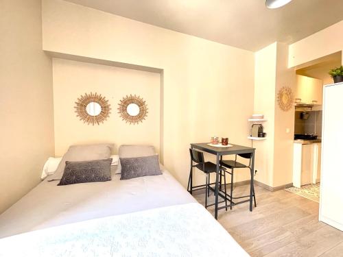 - une chambre avec un lit, une table et deux miroirs dans l'établissement Studio neuf à 2 pas du métro, aux Lilas