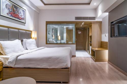 a bedroom with a large bed and a television at Regenta Place Amritsar by Royal Orchid Hotels Limited in Amritsar