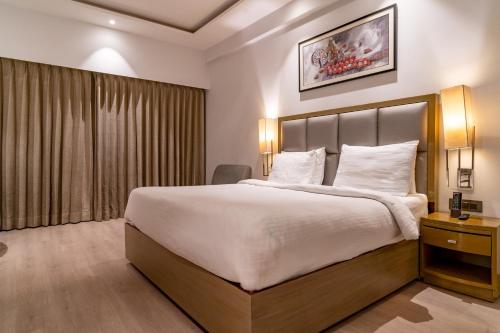 a hotel room with a large bed and a window at Regenta Place Amritsar by Royal Orchid Hotels Limited in Amritsar