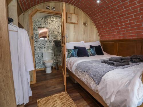 a bedroom with a bed with a brick wall at Rhosydd in Ruthin