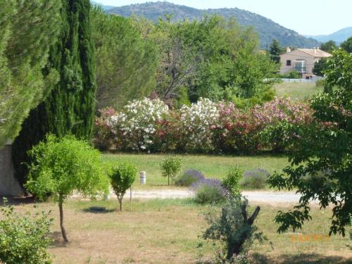 un jardin planté d'arbres et de fleurs dans l'établissement Villa THELISE, au Muy